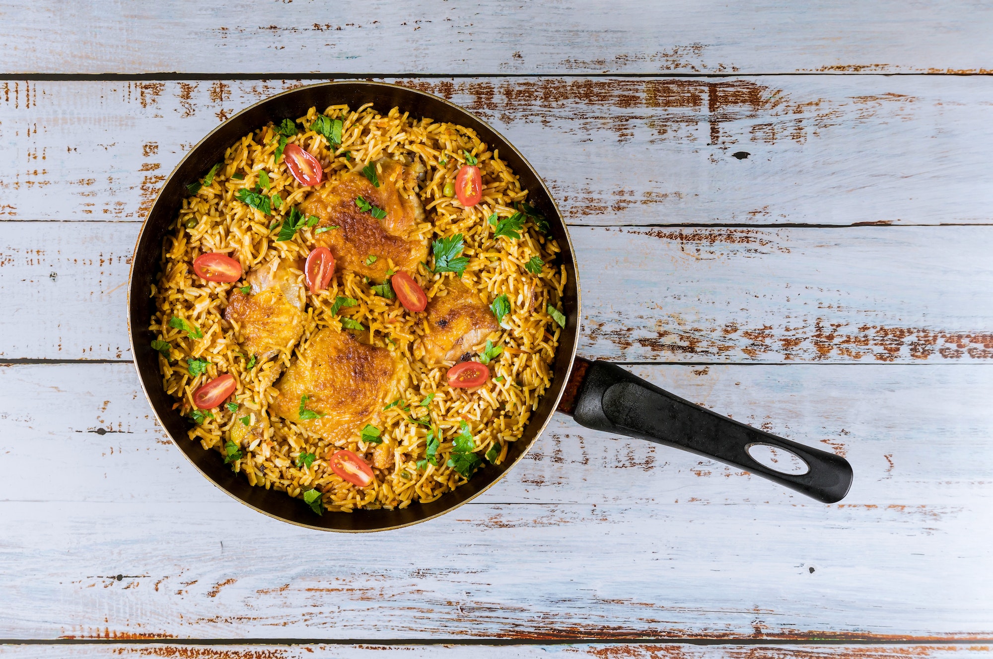 Asian rice and pasta with chicken and vegetables in pan.