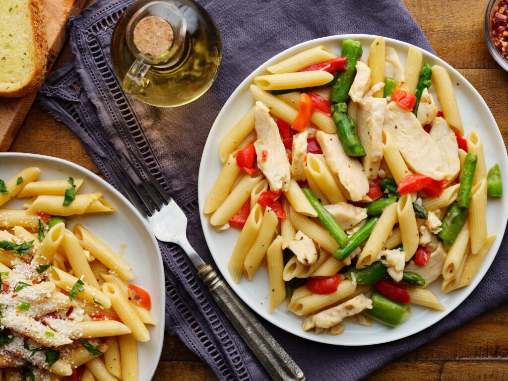 chicken penne pasta with red bell peppers and asparagus top down photo