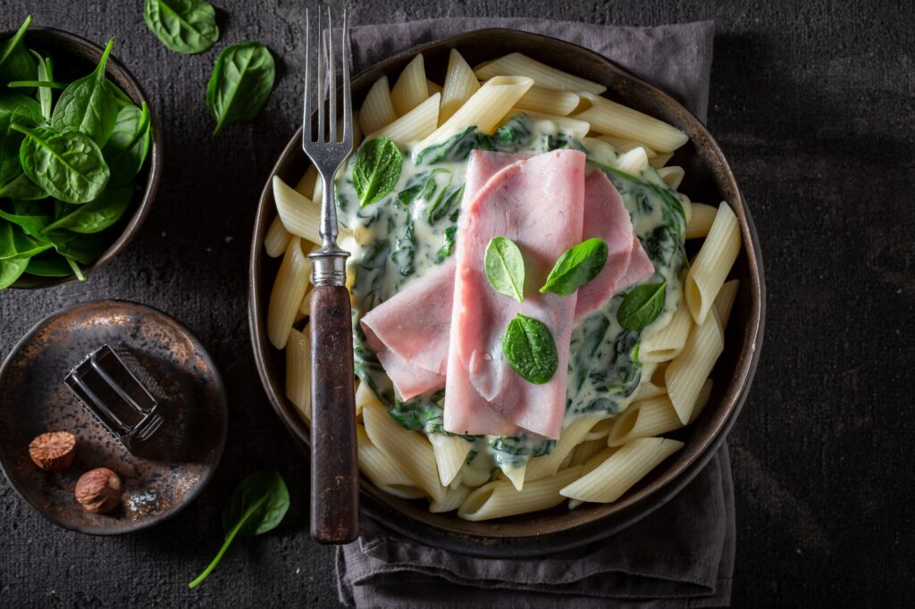 Delicious pasta with spinach, ham and bechamel sauce