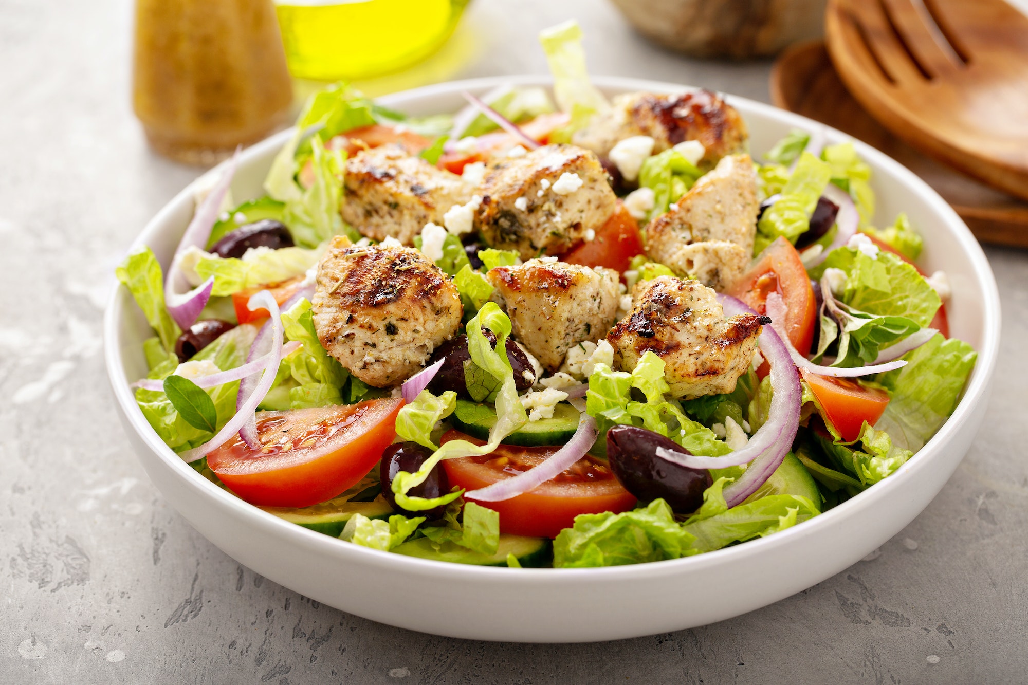 Greek salad with vinaigrette dressing topped with grilled chicken