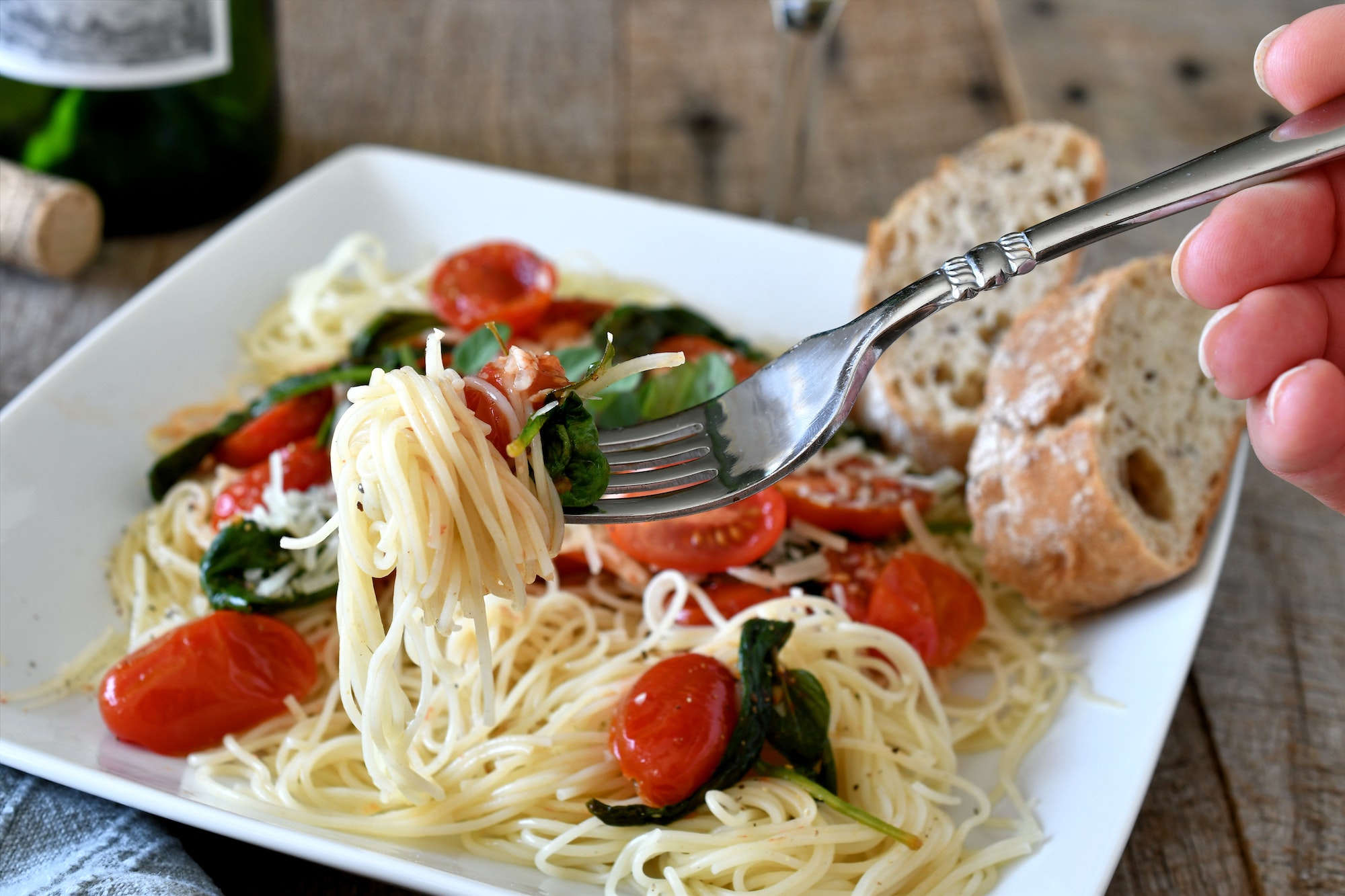 Italian angel hair pasta with fresh vegetables bread.. homemade meal, tomatoes, spinach