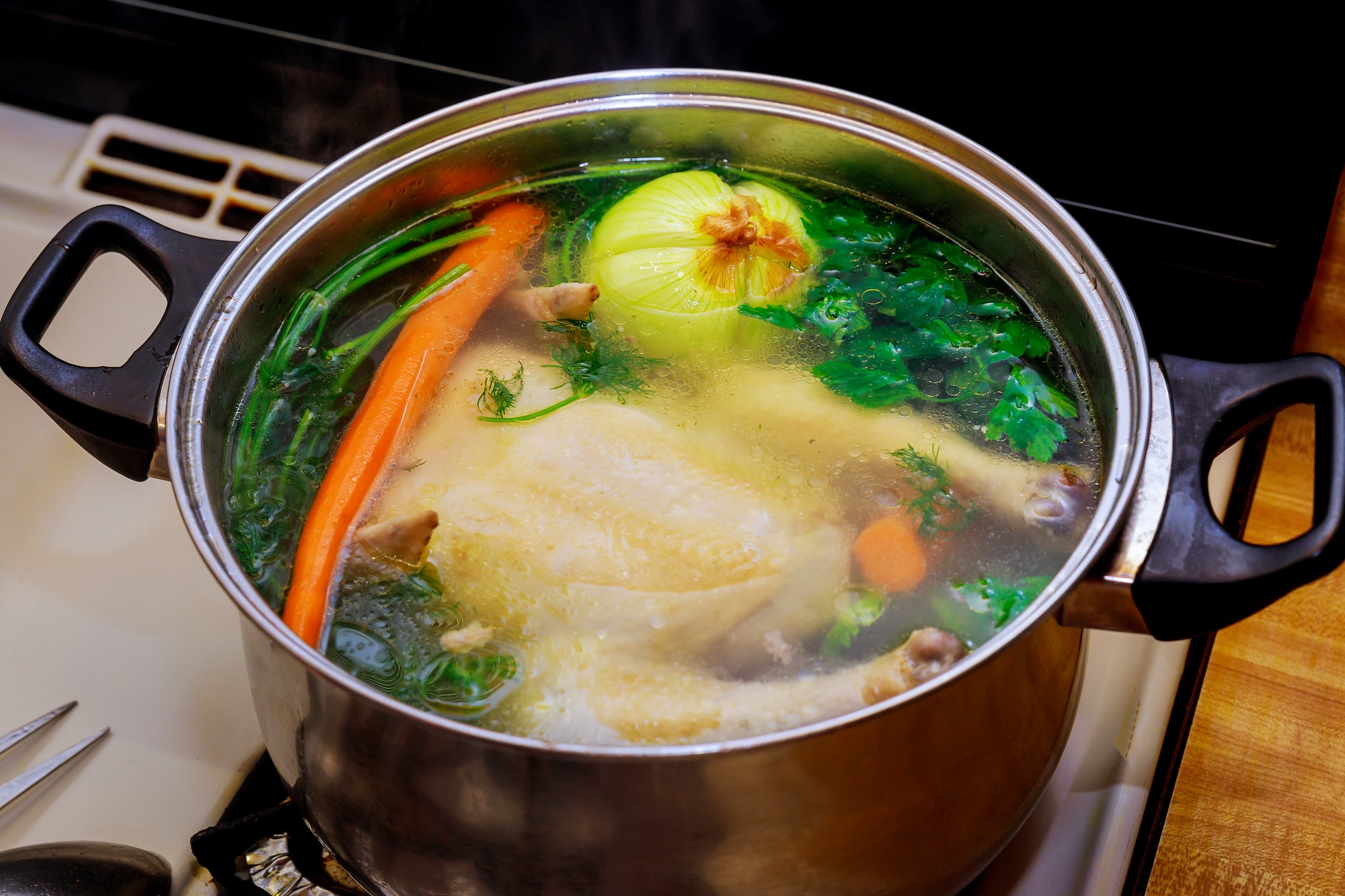 Chicken broth with carrots, whole chicken, onion, celery and parsley.