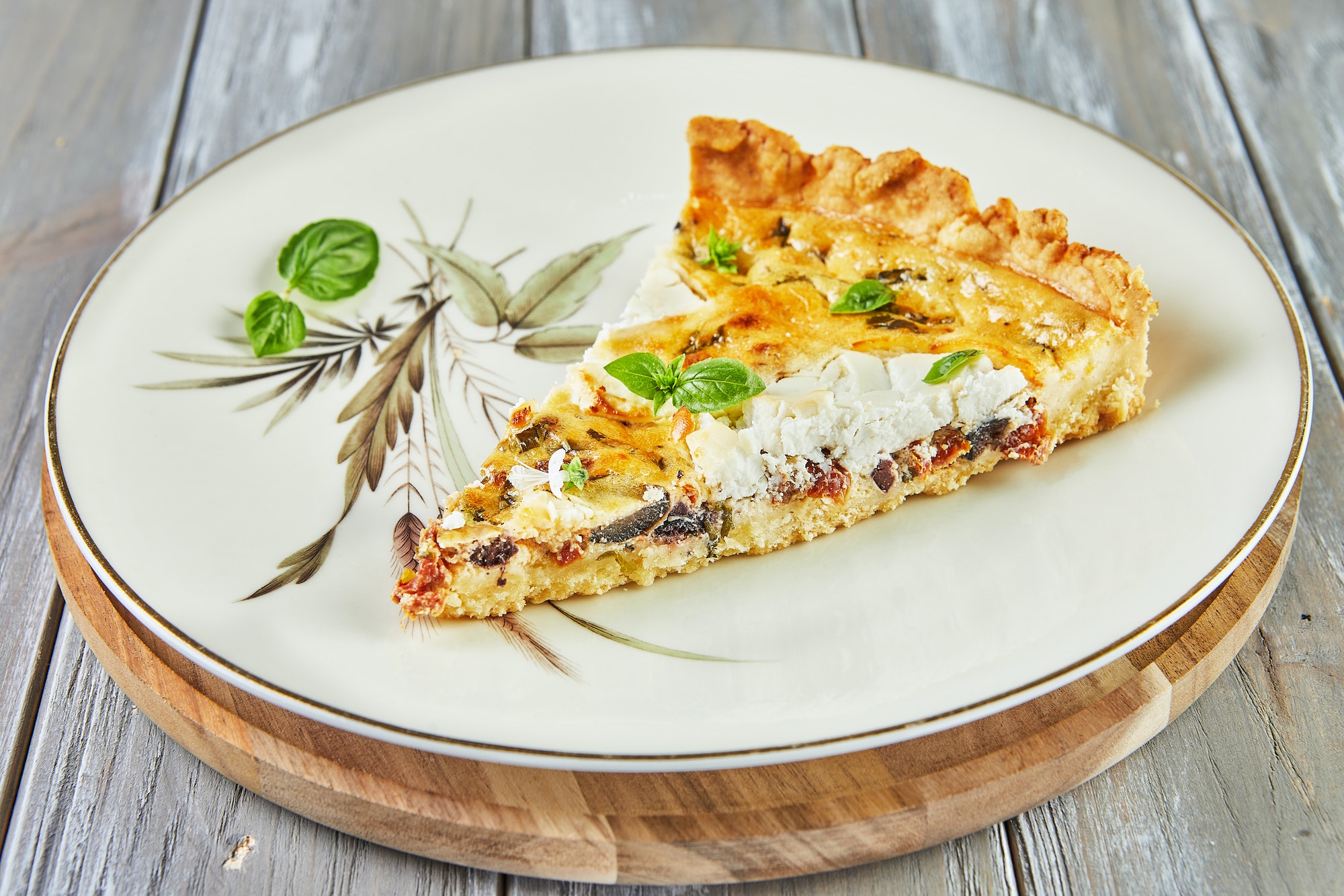 Piece of quiche with goat cheese on plate. French gourmet cuisine